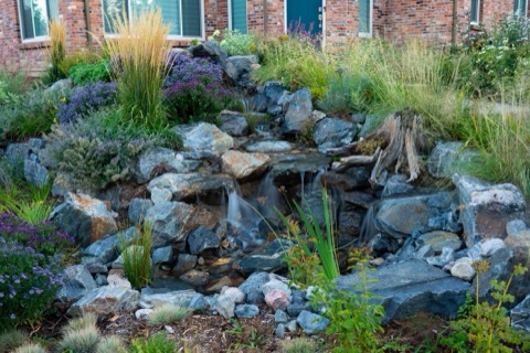 Front-yard pondless feature with brick house