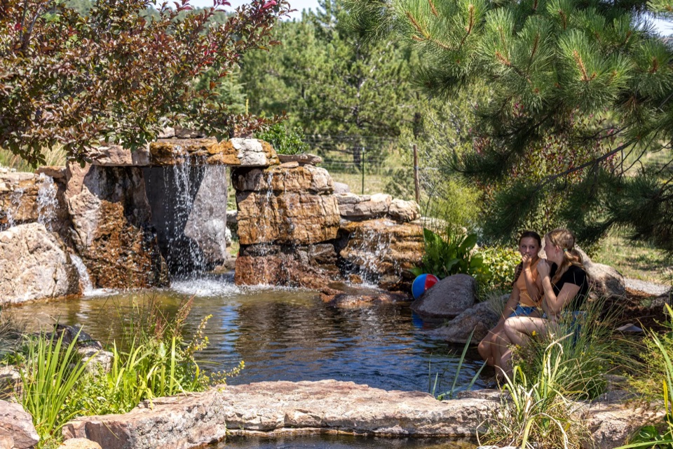 Grotto waterfall with family in the water