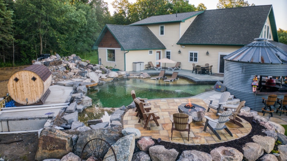 Natural swimming pool with a fire bowl, looking toward the house