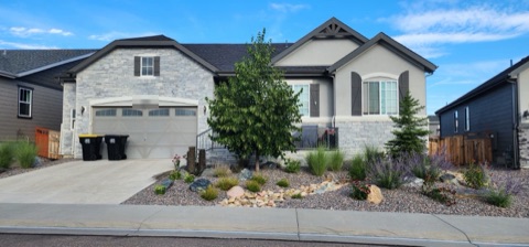 Front yard xeriscape with a river rock dry creek, boulders, a basalt column fountain, Russian sage and ornamental grasses